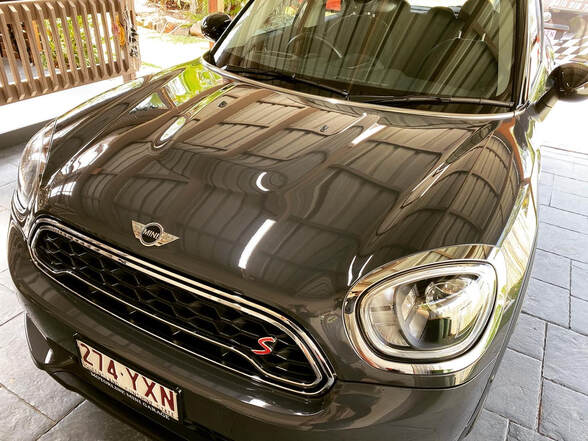 A Mini sits shining after a mobile car detail service